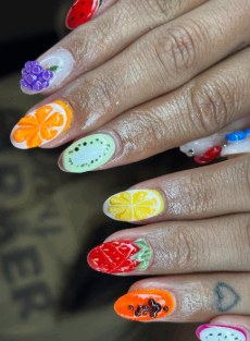 Bright fruit-themed nails with painted oranges, lemons and strawberries